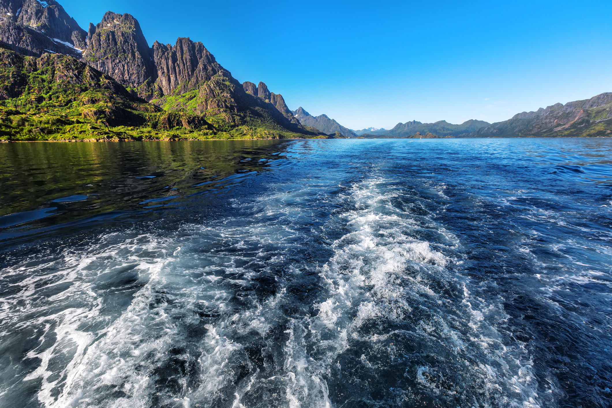 Vågorna bakom ett fartyg som kör på Trollfjorden i Lofoten, Norge.